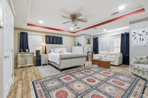 a bedroom with a large bed and a chandelier