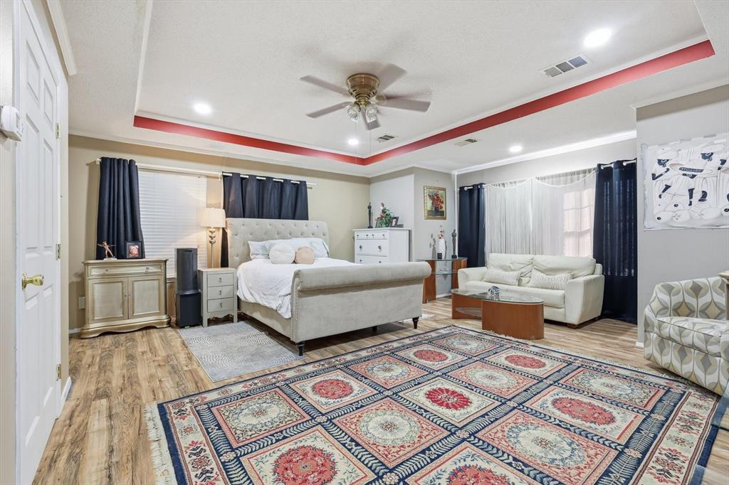 4208 Bretton Bay Circle Dallas, TX 75287 - Photo 18 of 32 a bedroom with a large bed and a chandelier