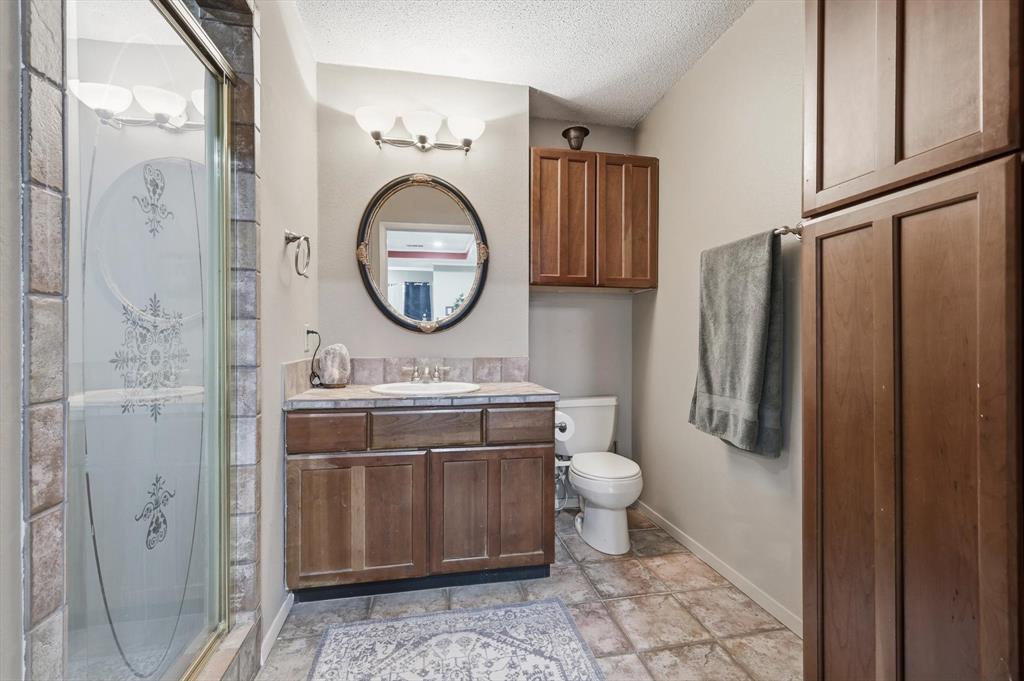 4208 Bretton Bay Circle Dallas, TX 75287 - Photo 20 of 32 a bathroom with a toilet a sink and a mirror
