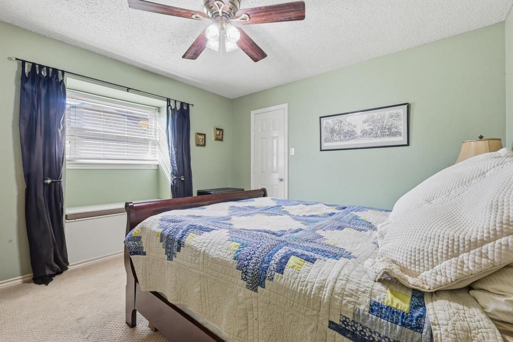 4208 Bretton Bay Circle Dallas, TX 75287 - Photo 21 of 32 a bedroom with a bed and a chandelier