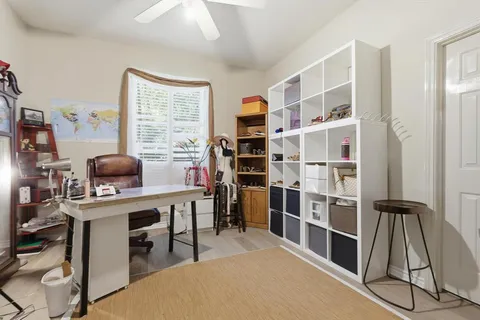 a view of a workspace with furniture and a window