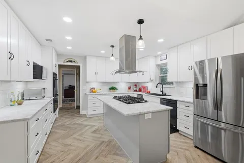 a kitchen with stainless steel appliances a stove refrigerator sink and microwave