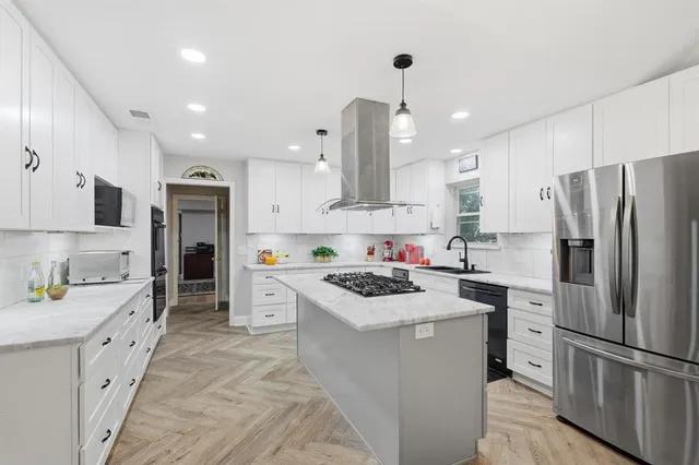 a kitchen with stainless steel appliances a stove refrigerator sink and microwave