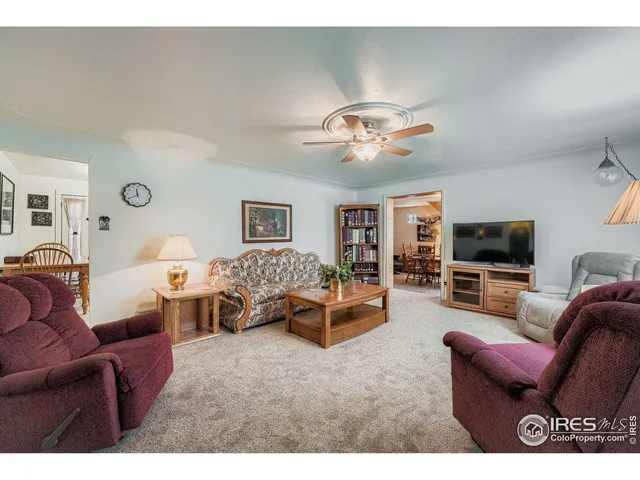a living room with furniture kitchen view and a flat screen tv