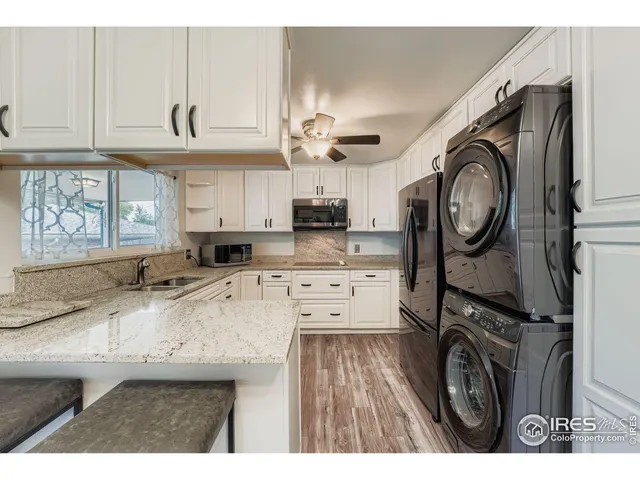 a kitchen with kitchen island granite countertop a stove a sink and a wooden cabinets