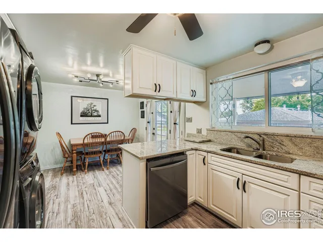 a kitchen with stainless steel appliances granite countertop a sink and a refrigerator