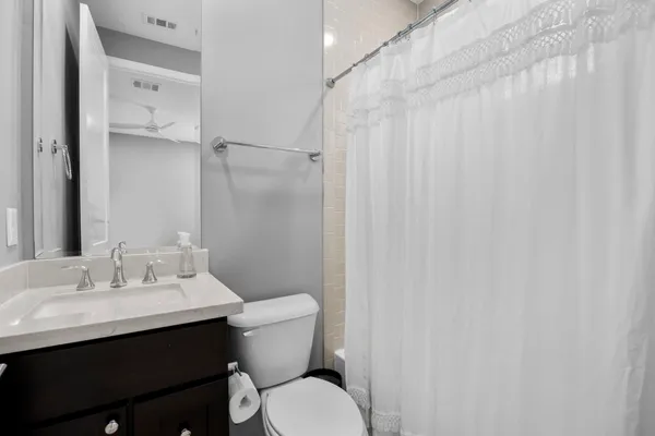 a bathroom with a sink vanity mirror and toilet