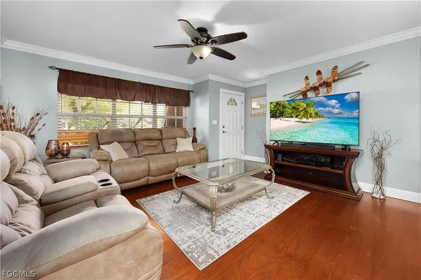 a living room with furniture a flat screen tv and a large window