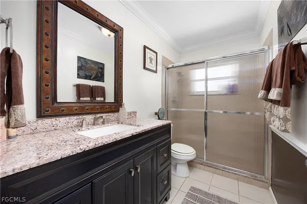 a bathroom with a granite countertop sink mirror vanity and toilet