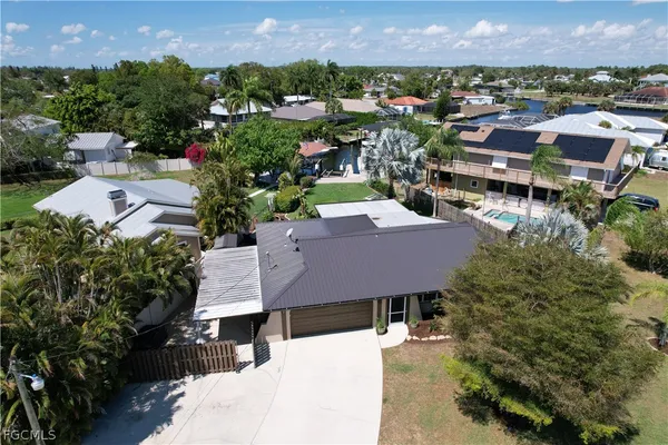 an aerial view of a house with a yard and lake view