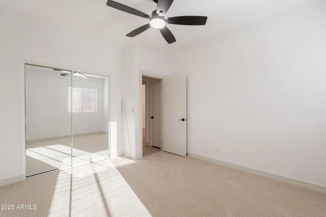 an empty room with a window and a fan