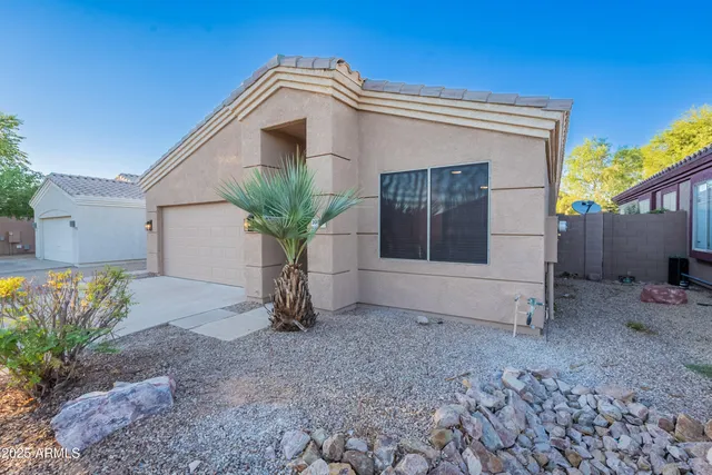 a view of a house with a yard and potted plants