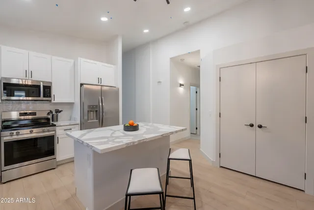 a kitchen with a refrigerator a stove and a sink