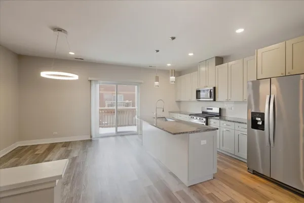 a kitchen with stainless steel appliances granite countertop a sink stove and refrigerator