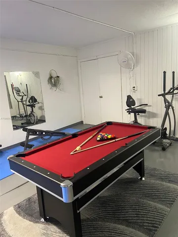 a room with pool table and windows