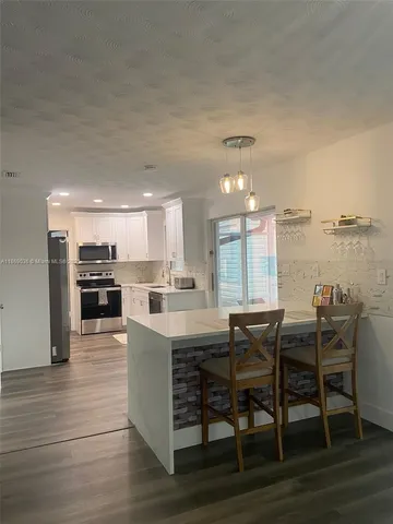 a view of a dining room kitchen with furniture and wooden floor