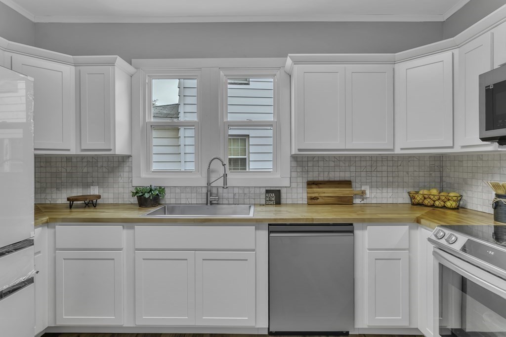 34 Brunswick Street Springfield, MA 01108 - Photo 11 of 31 a kitchen with stainless steel appliances white cabinets and a window