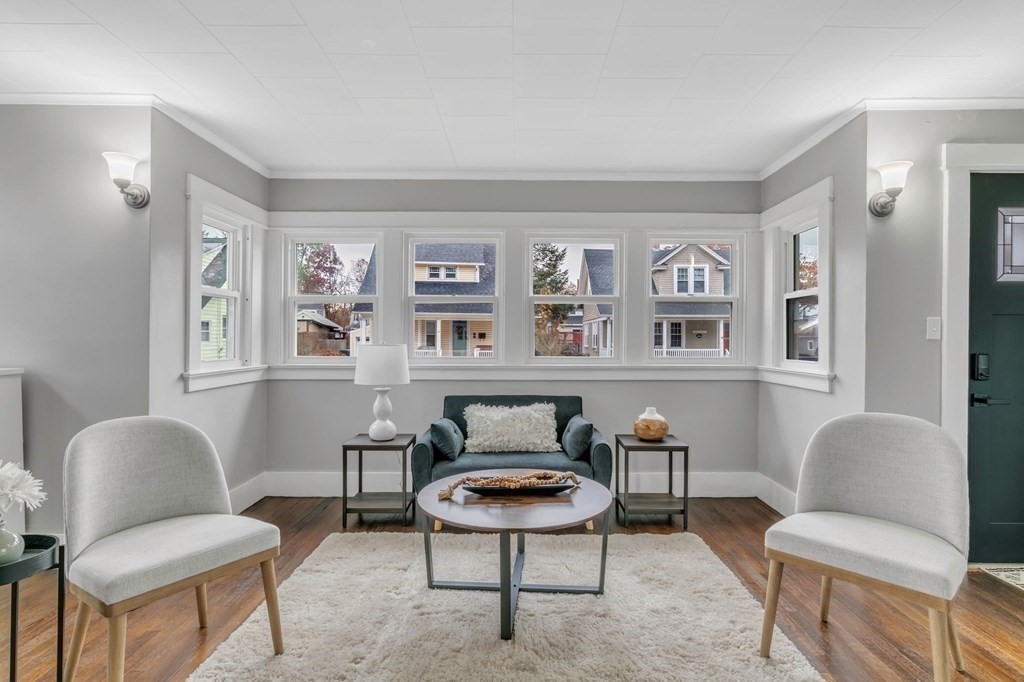 34 Brunswick Street Springfield, MA 01108 - Photo 3 of 31 a living room with furniture a couch and a bookshelf with wooden floor