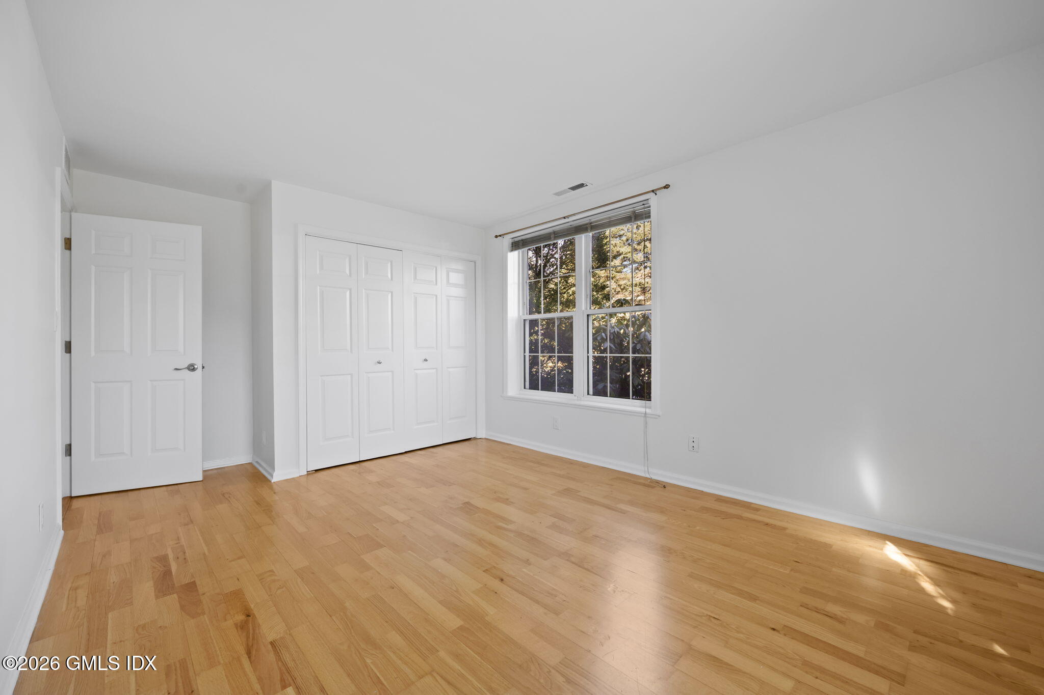 140 Field Point Road, Unit 2 Greenwich, CT 06830 - Photo 19 of 36 a view of an empty room with wooden floor and a window