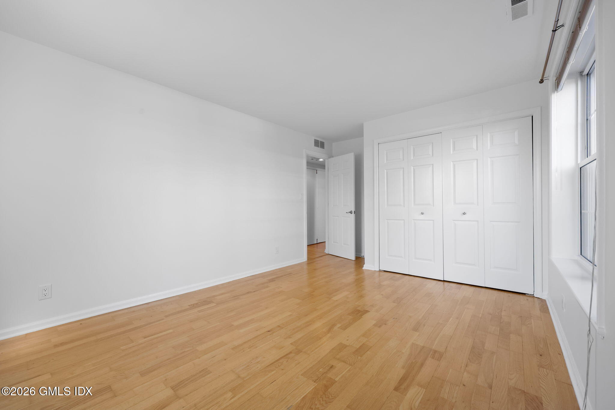 140 Field Point Road, Unit 2 Greenwich, CT 06830 - Photo 21 of 36 a view of an empty room with wooden floor and a window