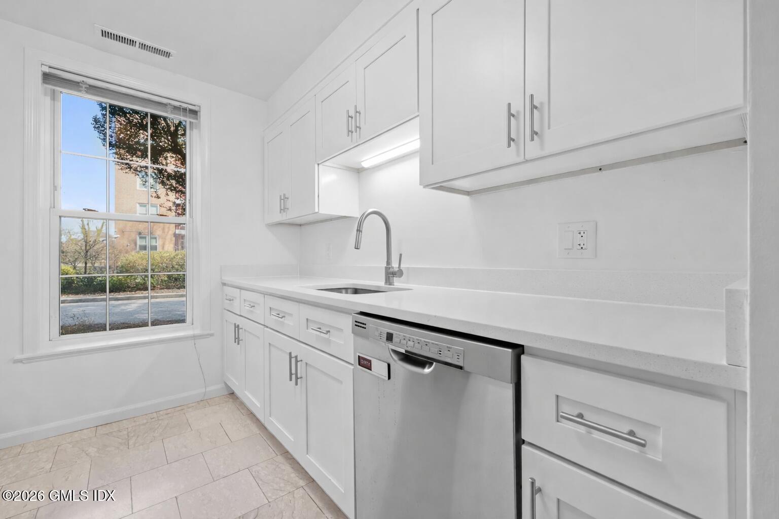 140 Field Point Road, Unit 2 Greenwich, CT 06830 - Photo 23 of 36 a kitchen with granite countertop white cabinets and a sink