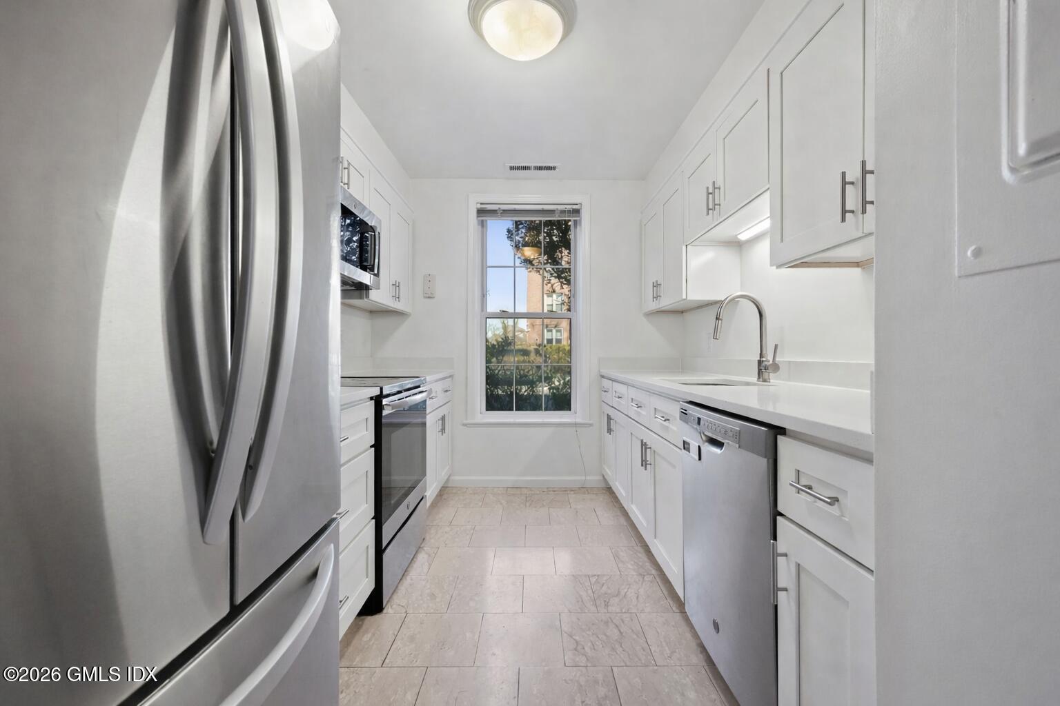 140 Field Point Road, Unit 2 Greenwich, CT 06830 - Photo 24 of 36 a kitchen with stainless steel appliances granite countertop a refrigerator a sink and white cabinets