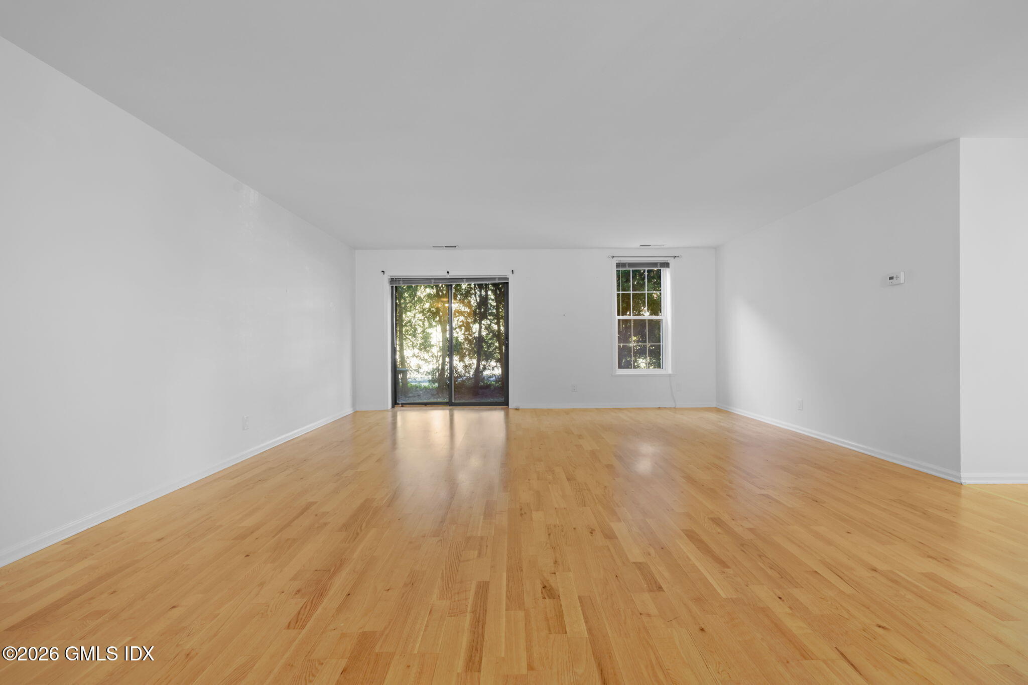 140 Field Point Road, Unit 2 Greenwich, CT 06830 - Photo 10 of 36 a view of an empty room with wooden floor and a window