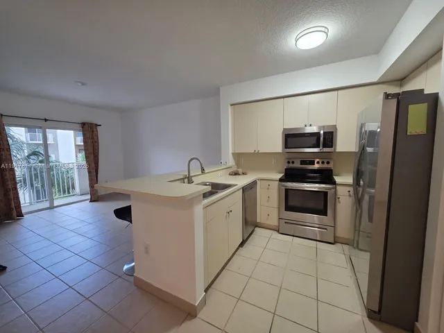 a kitchen with a sink appliances and cabinets