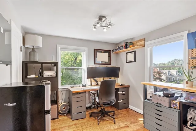 a view of a workspace with furniture and a window