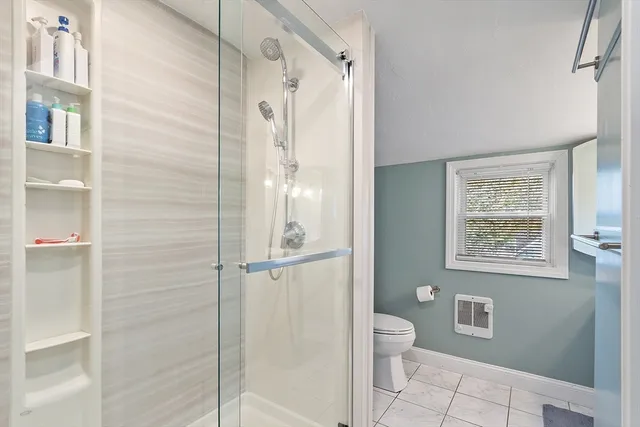 a bathroom with a granite countertop shower a toilet and a sink