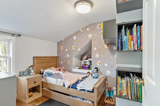 a living room with furniture a bookshelf and a window