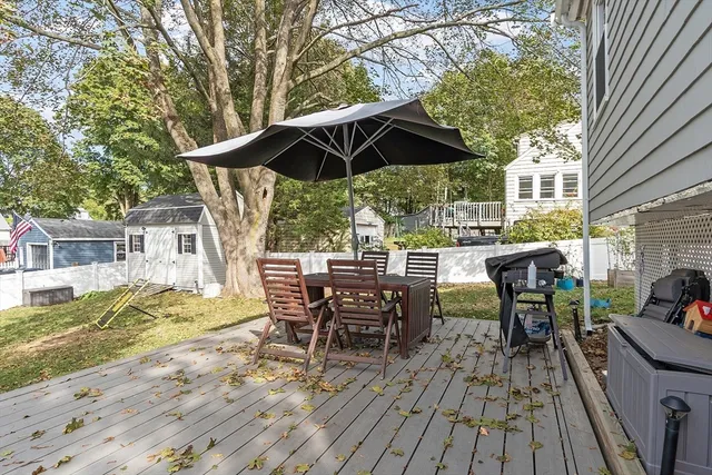 a view of backyard with table and chairs under an umbrella with wooden floor
