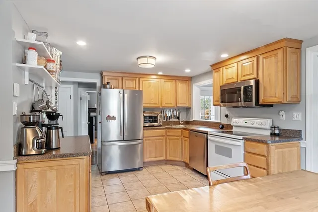 a kitchen with stainless steel appliances granite countertop a refrigerator a stove top oven a sink and dishwasher