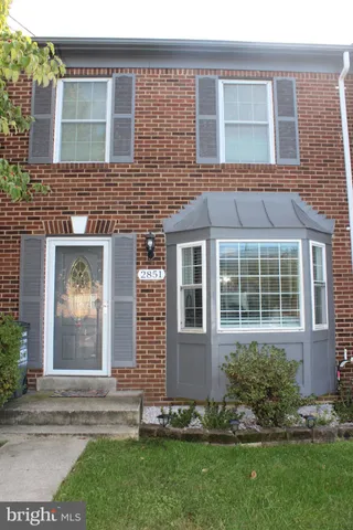 front view of a brick house with a yard