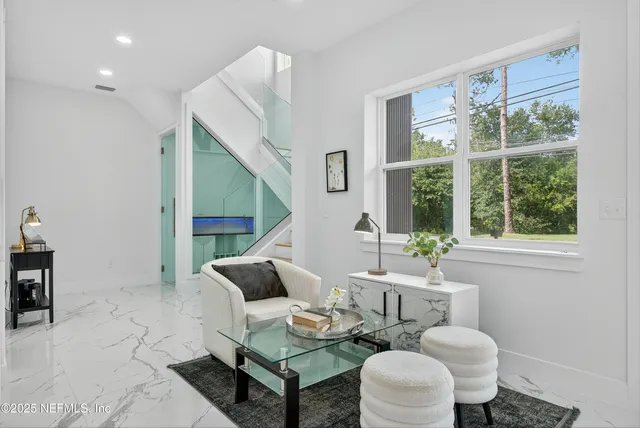 a kitchen that has a lot of white cabinets and stainless steel appliances