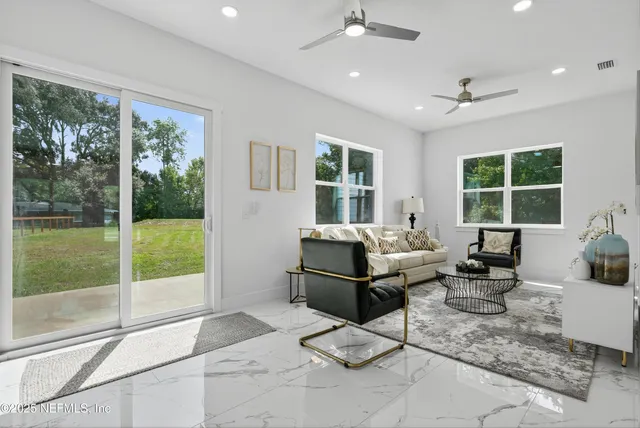 a view of a livingroom with wooden floor and a ceiling fan