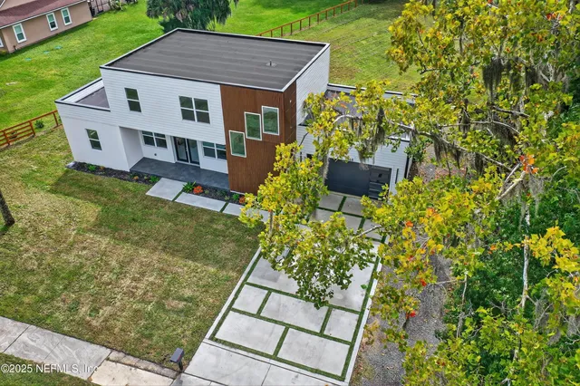 a living room with stainless steel appliances furniture a dining table and kitchen view