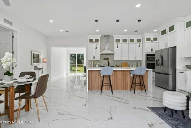 a living room with lots of furniture and white cabinets