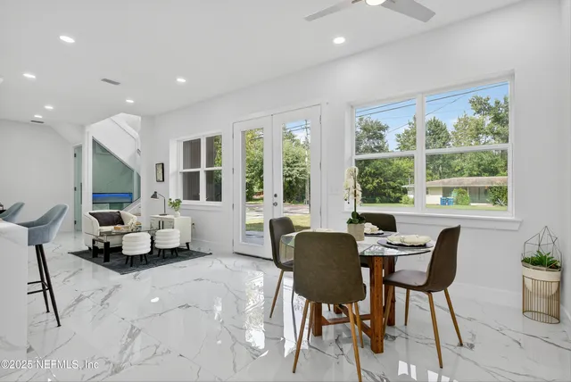 a kitchen with stainless steel appliances kitchen island granite countertop a dining table and chairs