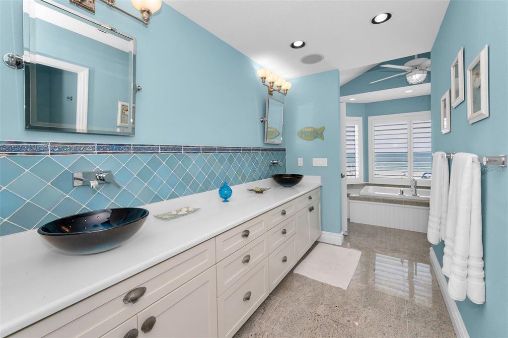 13303 Gulf Lane Madeira Beach, FL 33708 - Photo 17 of 42 a bathroom with a double vanity sink mirror and bathtub