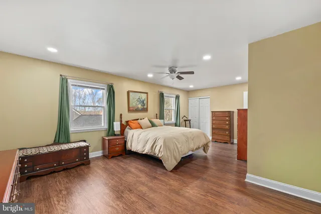 a spacious bedroom with a bed and wooden floor