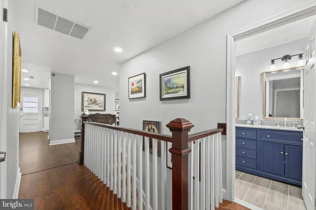 a view of a hallway with wooden floor and windows