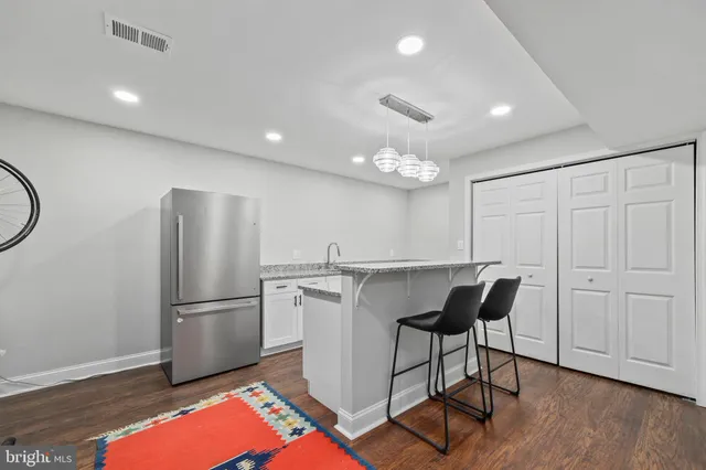 a kitchen with stainless steel appliances granite countertop a refrigerator and a stove top oven