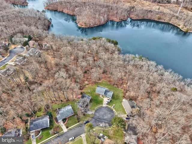 a aerial view of a house with a yard and lake view