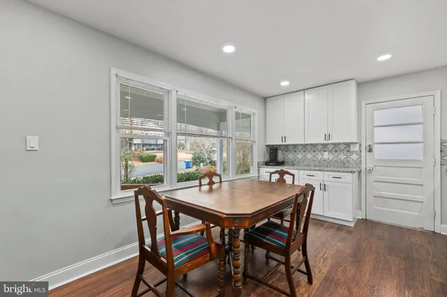 a kitchen with a table chairs and wooden floor