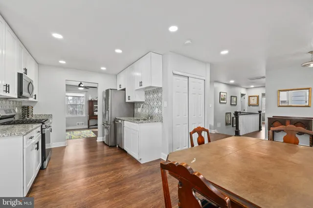 a kitchen with stainless steel appliances kitchen island granite countertop a refrigerator and a stove top oven