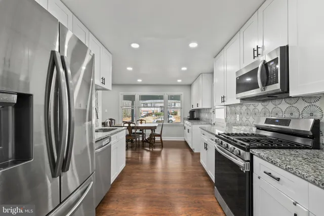 a kitchen with stainless steel appliances granite countertop a refrigerator stove microwave and sink