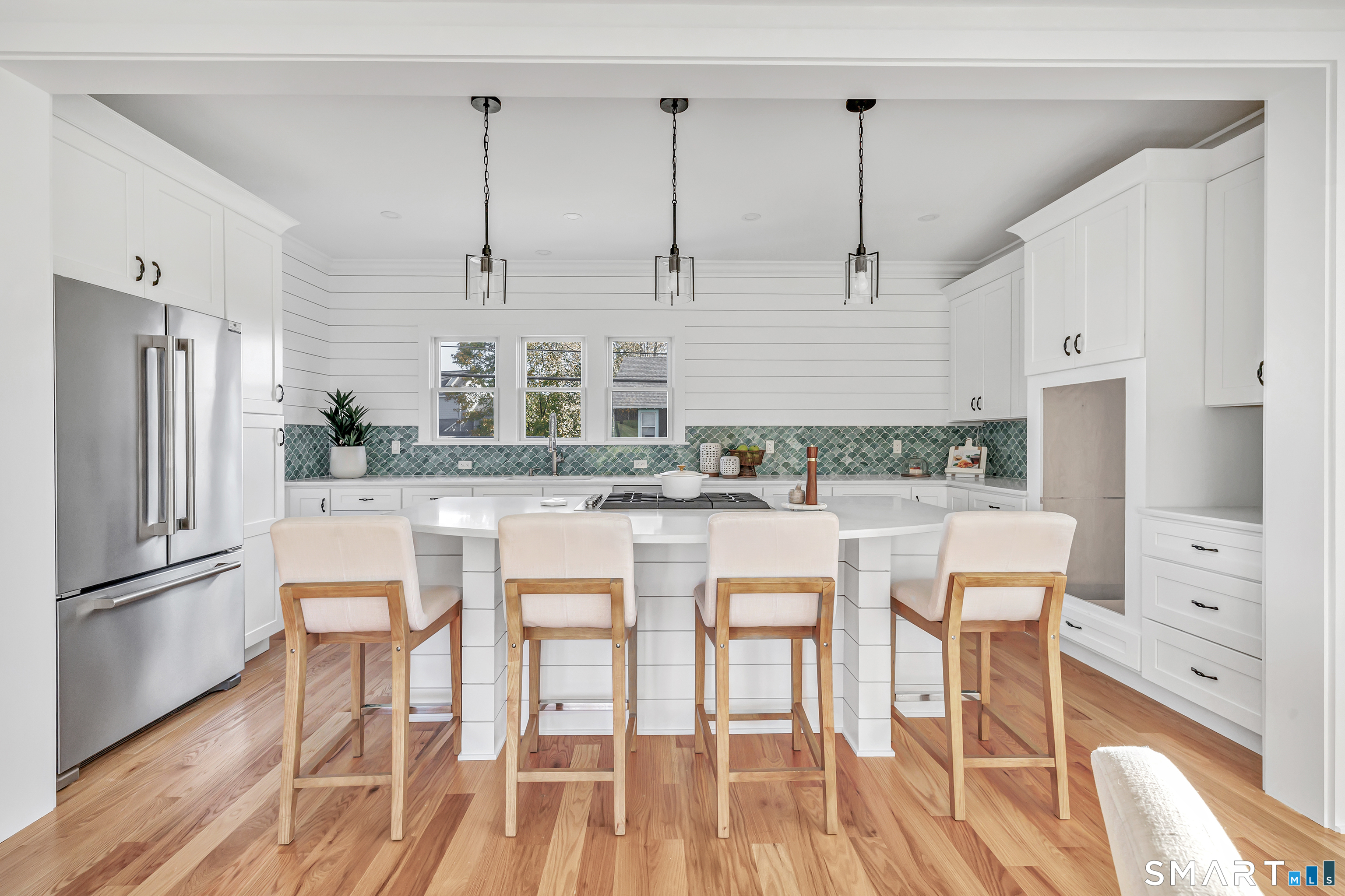 212 Milford Point Road Milford, CT 06460 - Photo 11 of 40 a kitchen with stainless steel appliances granite countertop a refrigerator a stove and white cabinets with wooden floor