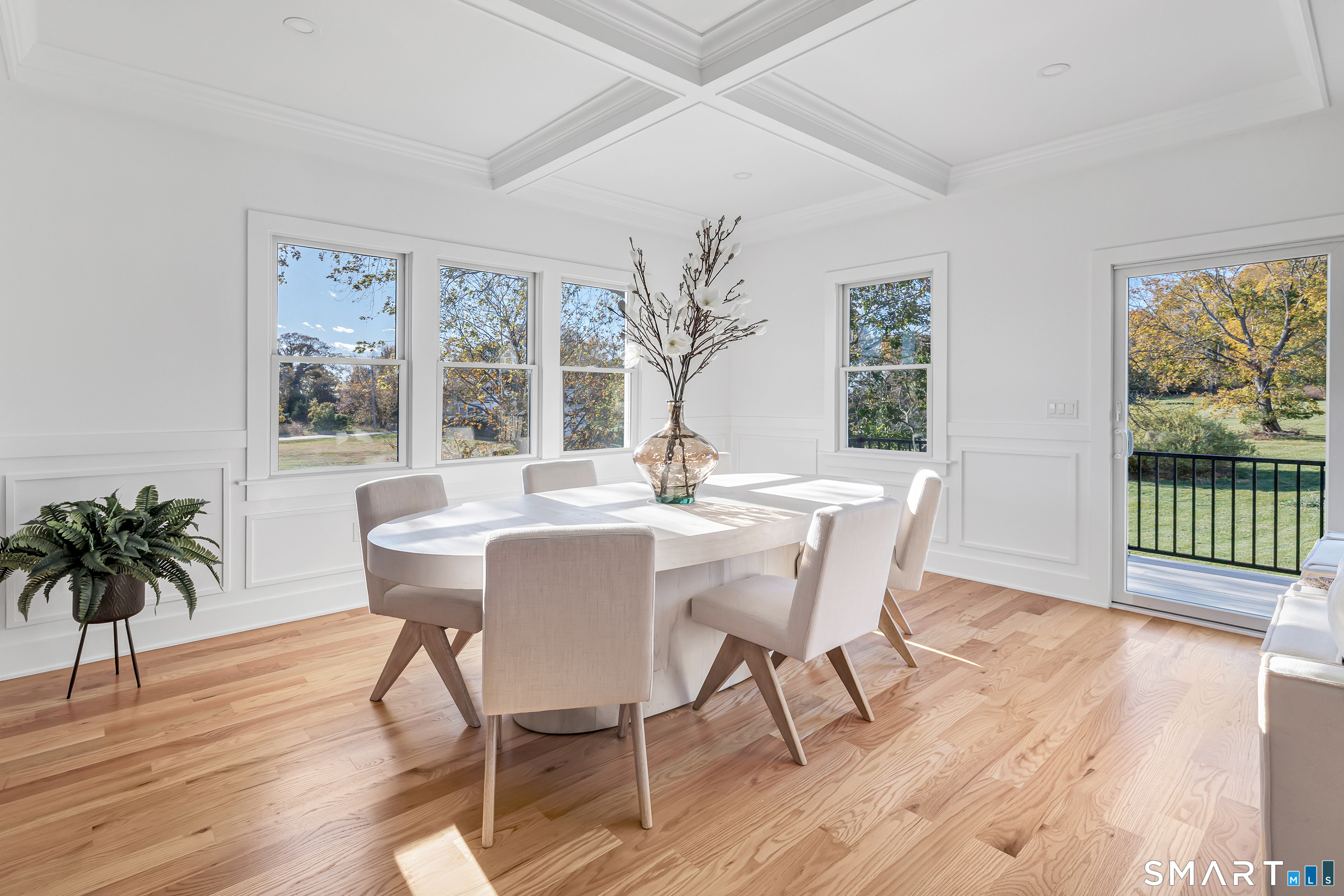 212 Milford Point Road Milford, CT 06460 - Photo 14 of 40 a dining room with wooden floor a glass table and chairs