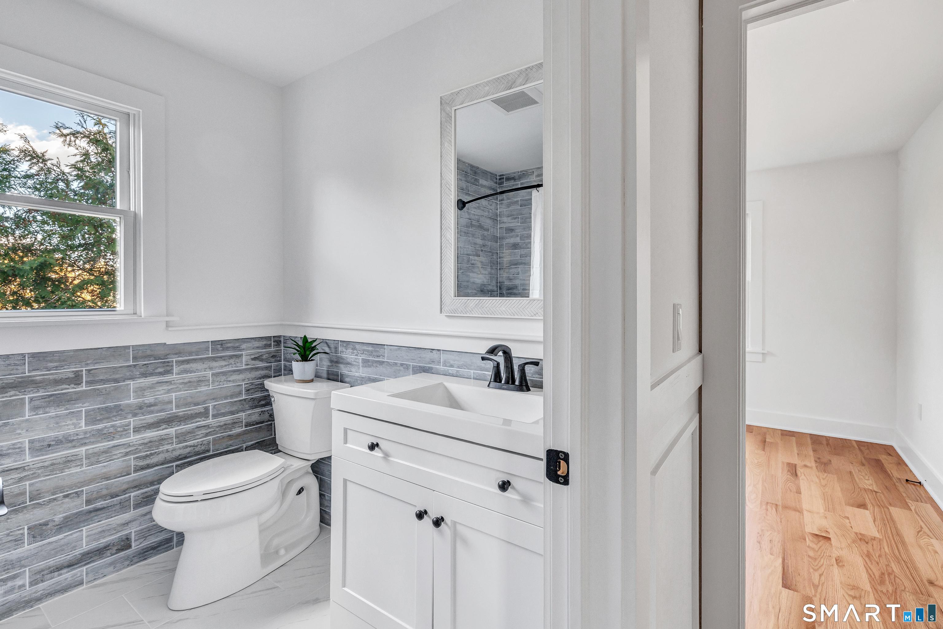 212 Milford Point Road Milford, CT 06460 - Photo 30 of 40 a bathroom with a toilet sink and mirror